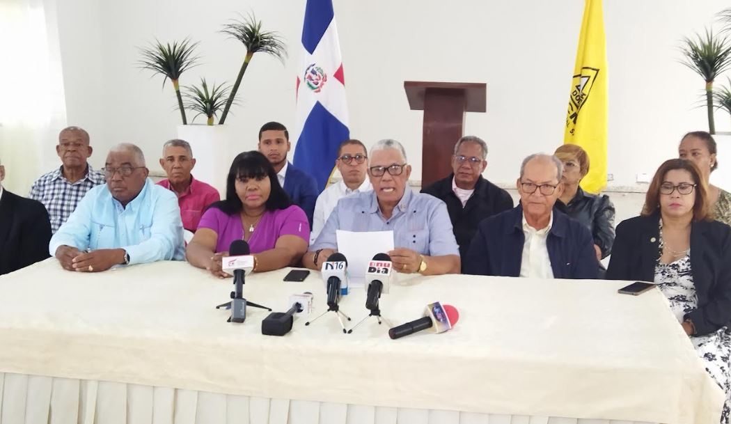 Roque García, presidente de la Comisión de Deportes Universitarios de Miderec, premia a la O & M como la ganadora del torneo de taekwondo en la versión 2023. Desde la izquierda, Aquilina Frías, de la UNPHU, García y Carlos Manuel Carrasco entrenador del equipo campeón.