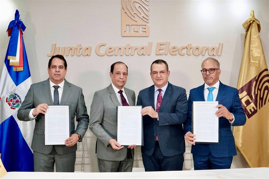El presidente de la JCE, Román Andrés Jáquez Liranzo, y el miembro titular Rafael Armando Vallejo Santelises, junto a representantes del consorcio EMDOC, durante la firma del contrato para la renovación de la Cédula de Identidad y Electoral en la sede central de la institución. Foto: Fuente externa.
