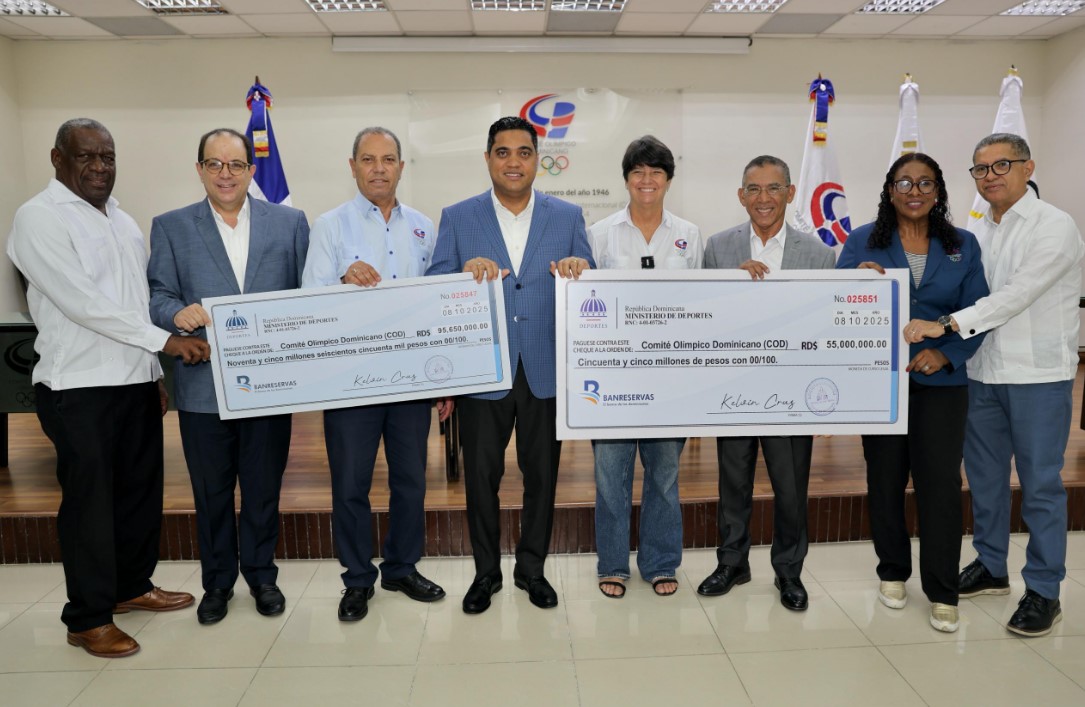 El ministro de Deportes, Kelvin Cruz, entrega de manera simbólica los cheques al presidente del COD, Garibaldy Bautista. En la gráfica, funcionarios de Deportes y directivos de la entidad olímpica.