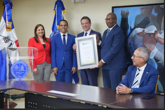 El rector de la UASD, maestro Editrudis Beltrán, mientras entrega el reconocimiento al ministro del MICM.