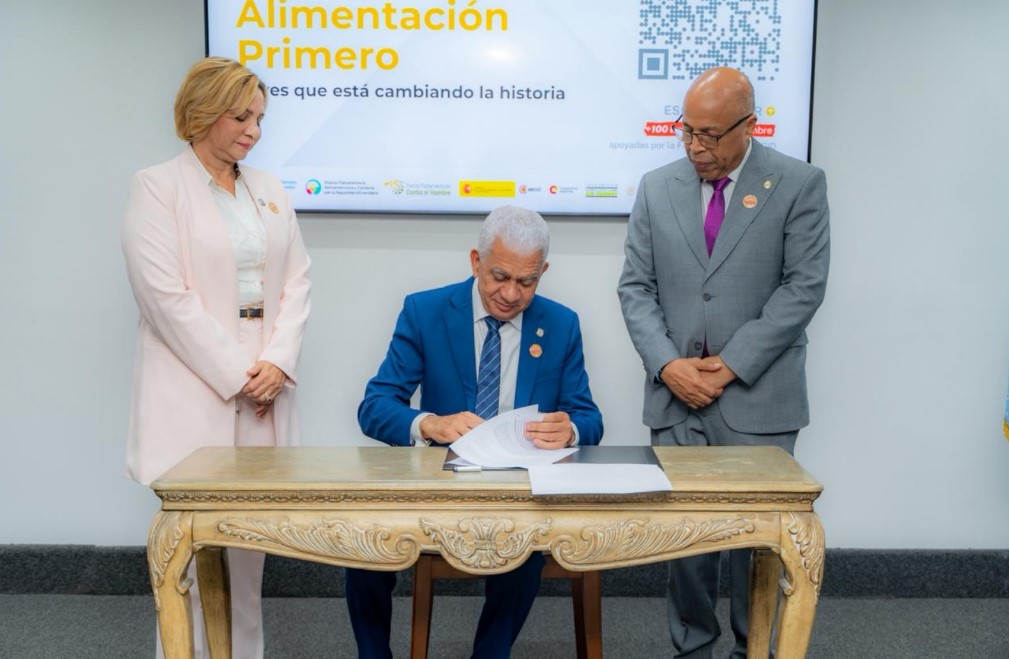 Presidente del Senado Ricardo de los Santos firma el Pacto y observan el presidente de la Cámara de Diputados Aldfredo Pacheco y la diputada Soraya Suárez