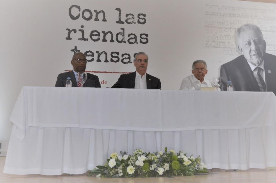 El presidente Luis Abinader y el rector de la UASD, maestro Editrudis Beltrán, junto al autor de la obra, Juan Bolívar Díaz en la mesa de honor.