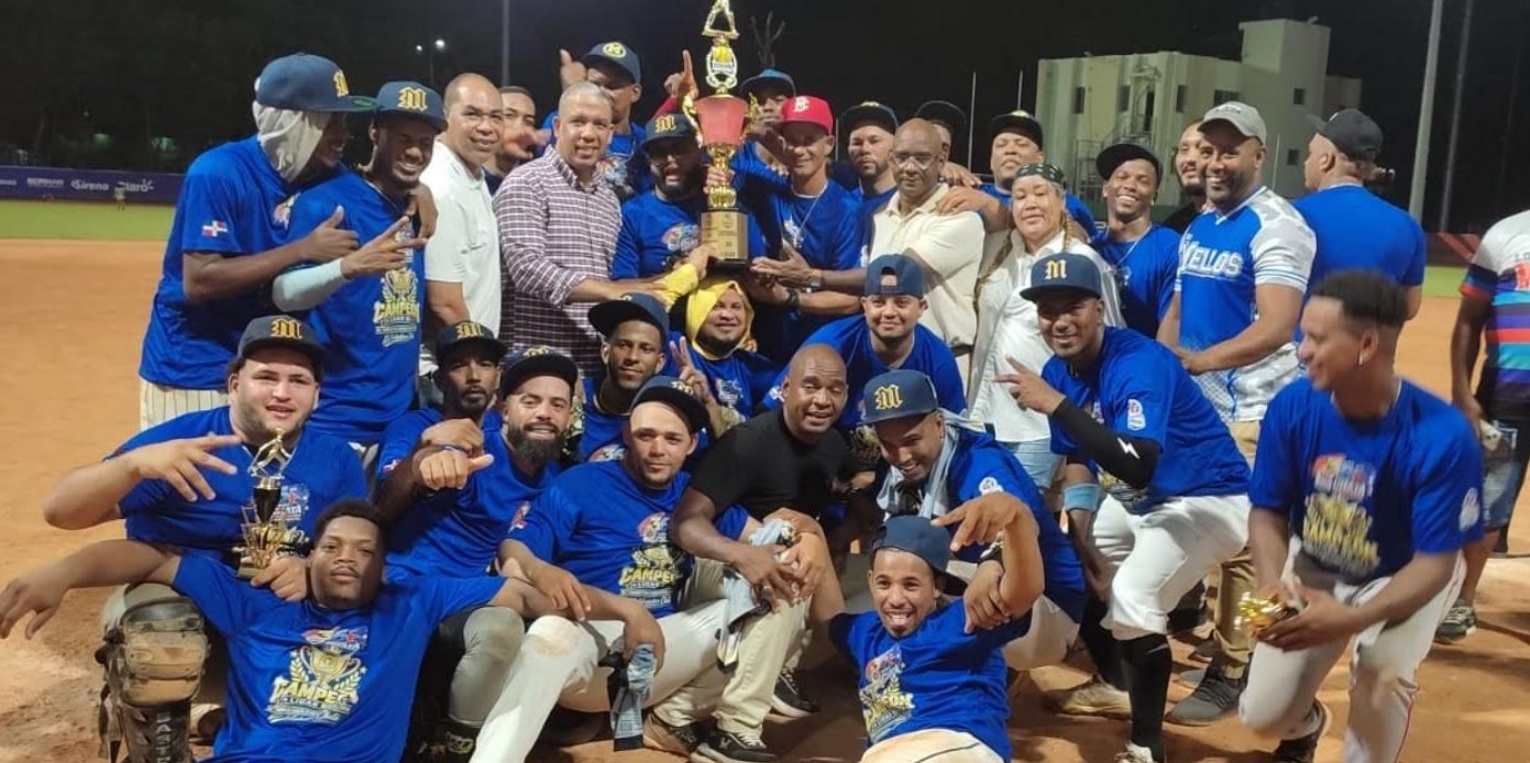 Aneudy Liven, homenajeado del torneo, y Apolinar Durán, presidente de la Asociación de Softbol del Distrito Nacional, entregan a los integrantes de Los Mellos el trofeo que los acredita como campeones del 36 torneo de softbol Rubén Pimentel 2026. (Fuente externa)